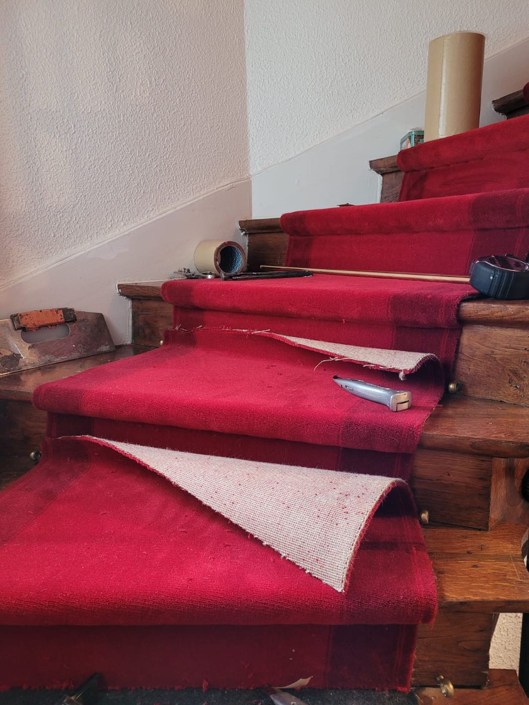 Découpe et ajustement du tapis rouge sur l'escalier