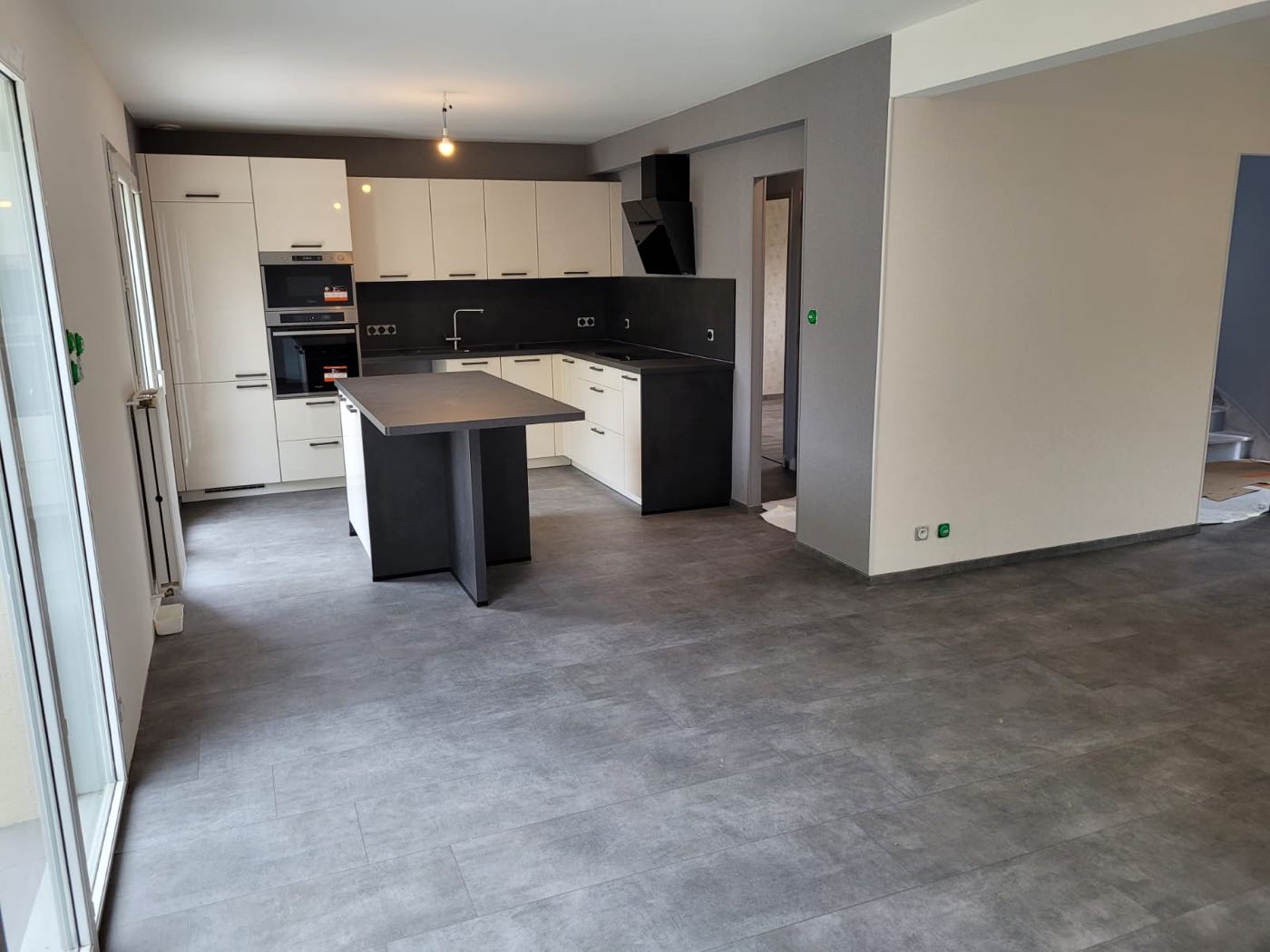 Sol vinyle imitation carrelage gris dans une cuisine ouverte
